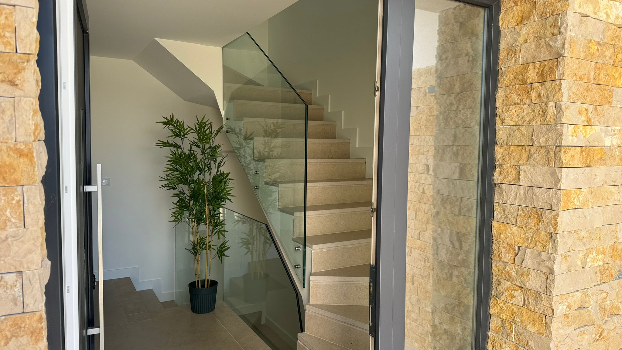 Stone entrance with glass staircase