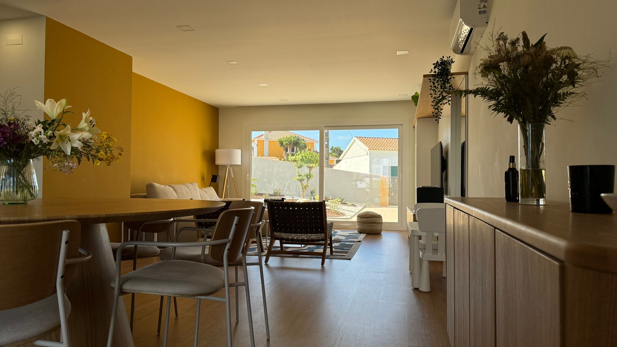 Living room with golden yellow accent wall at Azul Ericeira